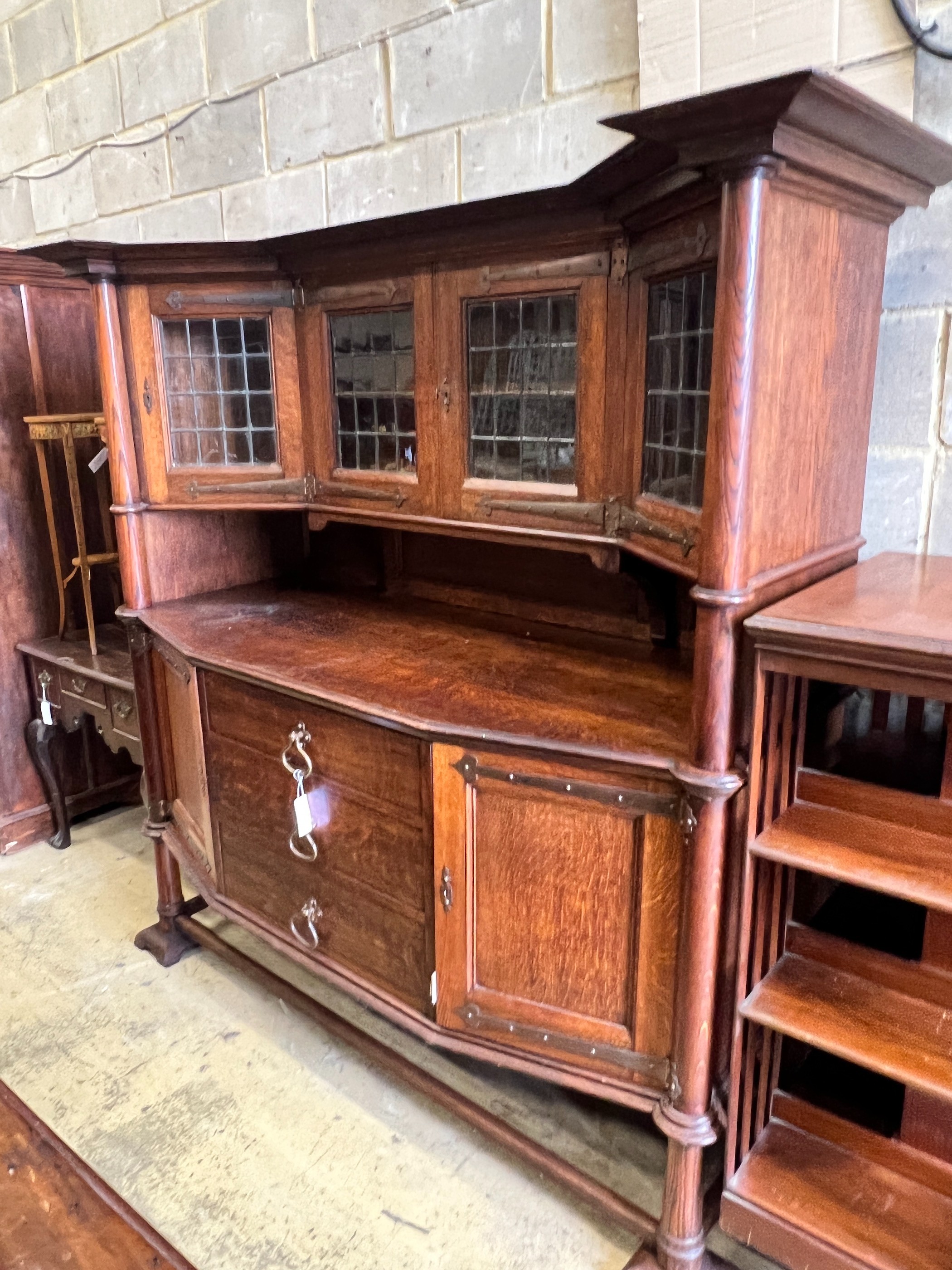 An early 20th century Arts & Crafts copper mounted oak sideboard in the manner of Shapland and Petter, stamped Warings, Oxford Street, London, length 168cm, width 64cm, height 180cm